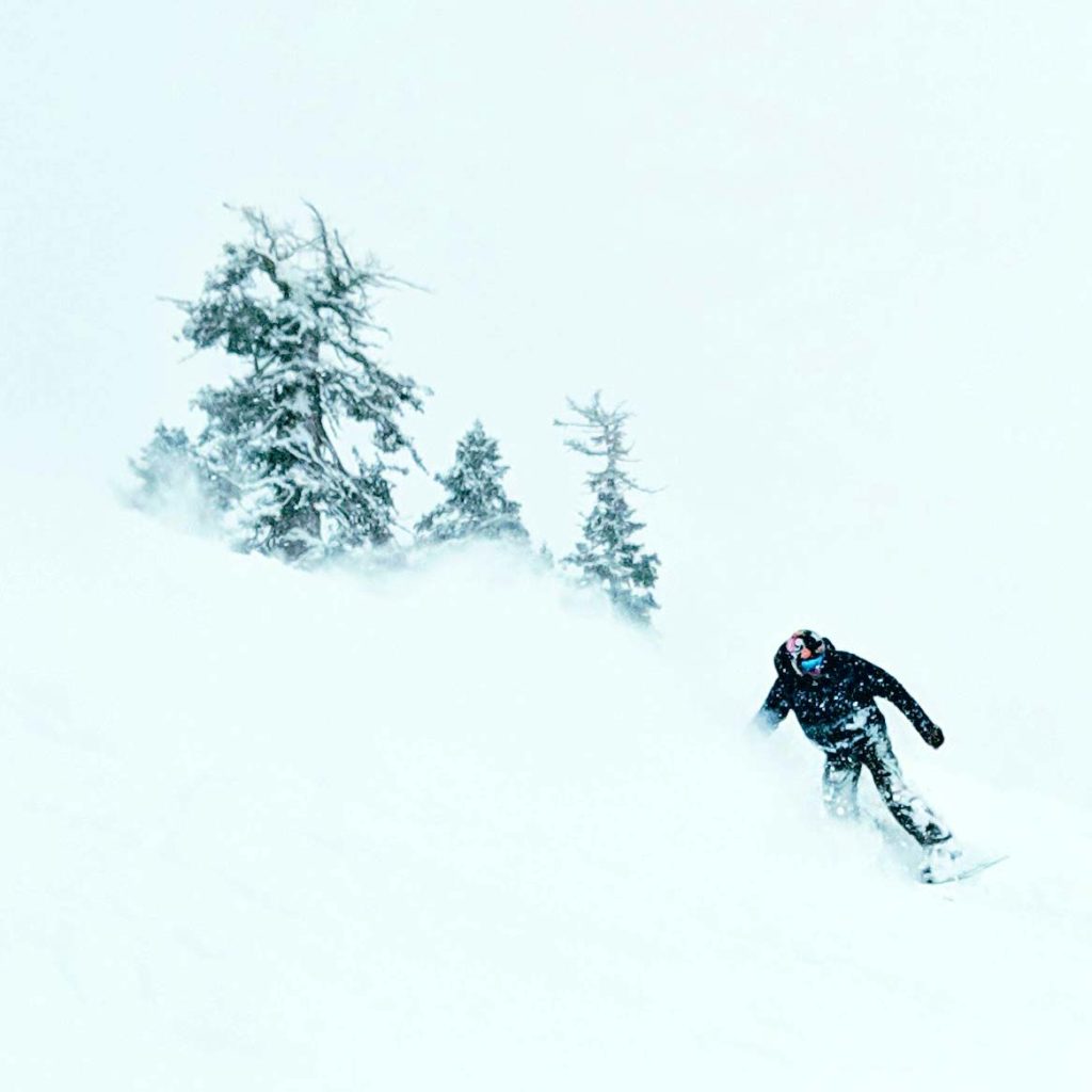 Snowboarder riding deep powder at Sugar Bowl ski resort
